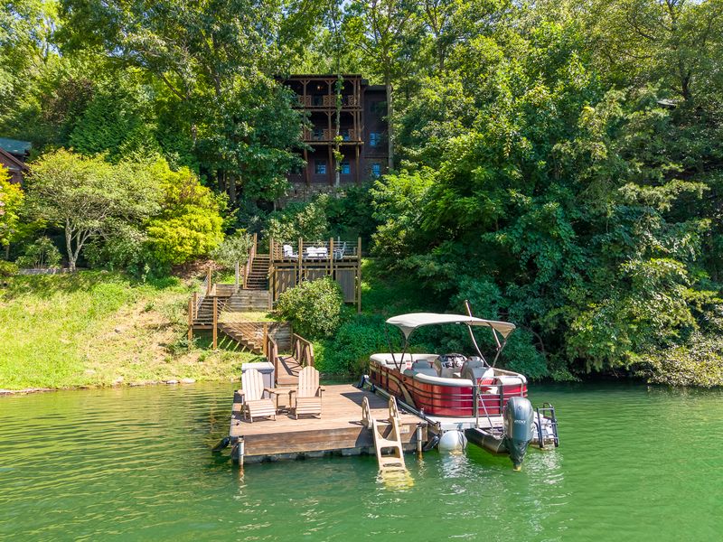 The Treehouse above its dock and pontoon boat, seen from the lake