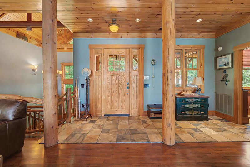 Front door and slate foyer with a log post