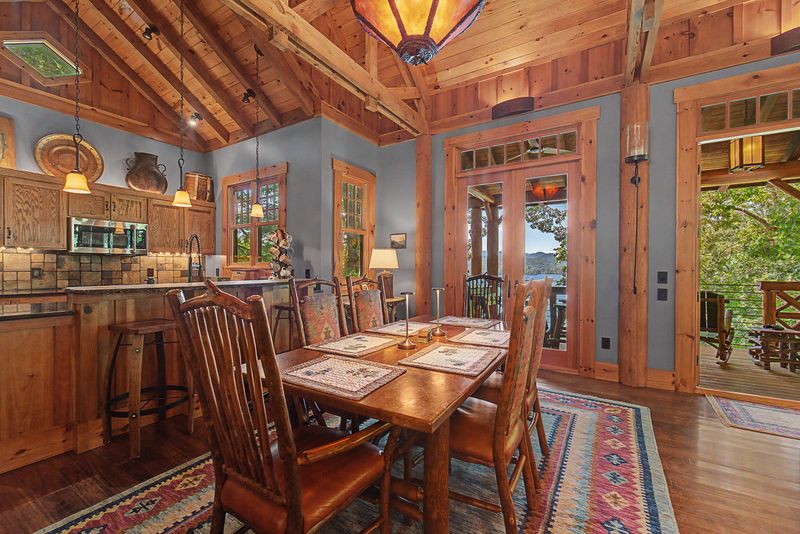 Dining table set under the trusses with doors to the deck