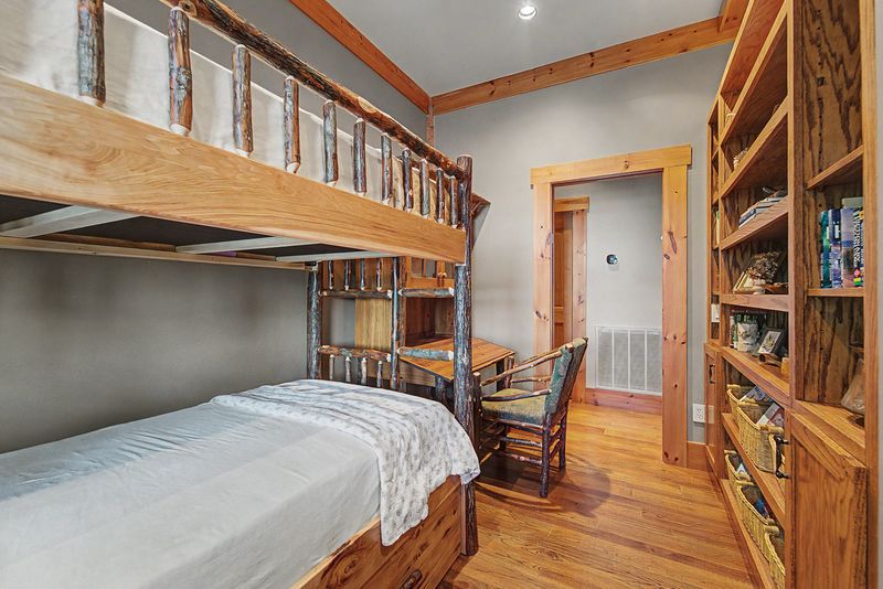 Bunk room with log bunk beds and a built-in desk