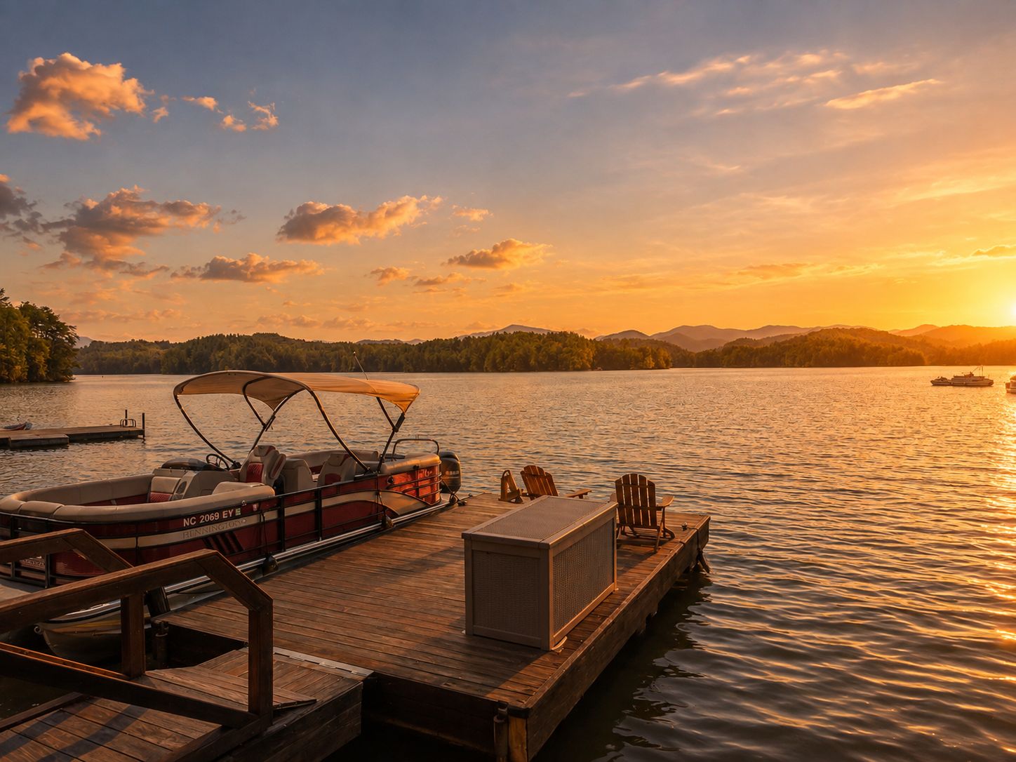 Private dock with a pontoon boat and Adirondack chairs, the sun setting over Lake Santeetlah